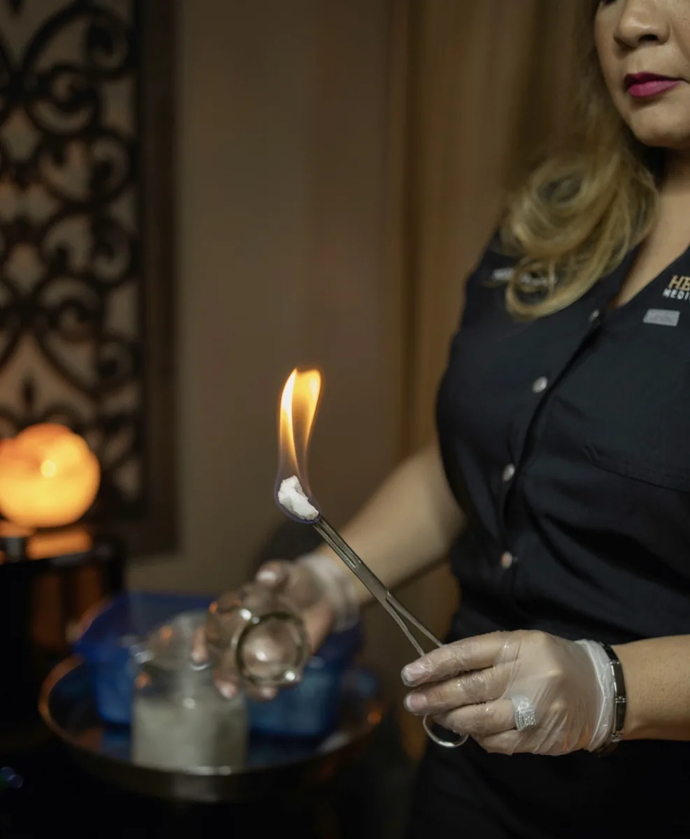 Dr. Rusnak lighting the cotton swab used to seat a fire cup, in the treatment room