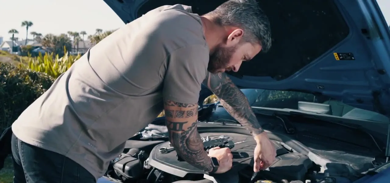 A man back at work under the hood of his car after recovery