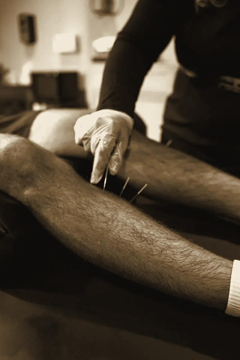 Dr. Rusnak placing needles along a patient's leg